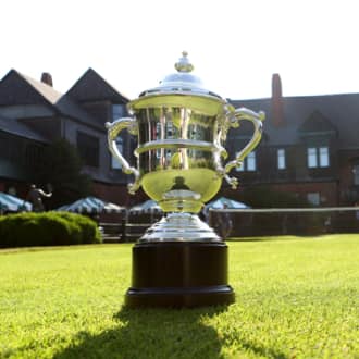 A silver tennis trophy sits on the grass at the International Tennis Hall of Fame.
